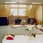 Banquet room area with white table cloth and table settings